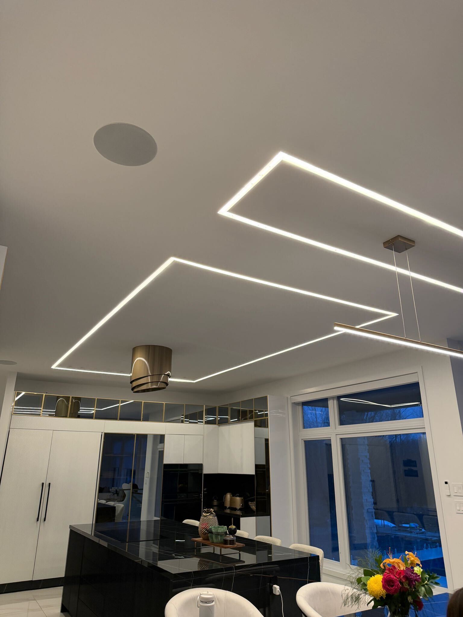 Custom LED strip lighting in kitchen ceiling with overlapping rectangular geometric patterns