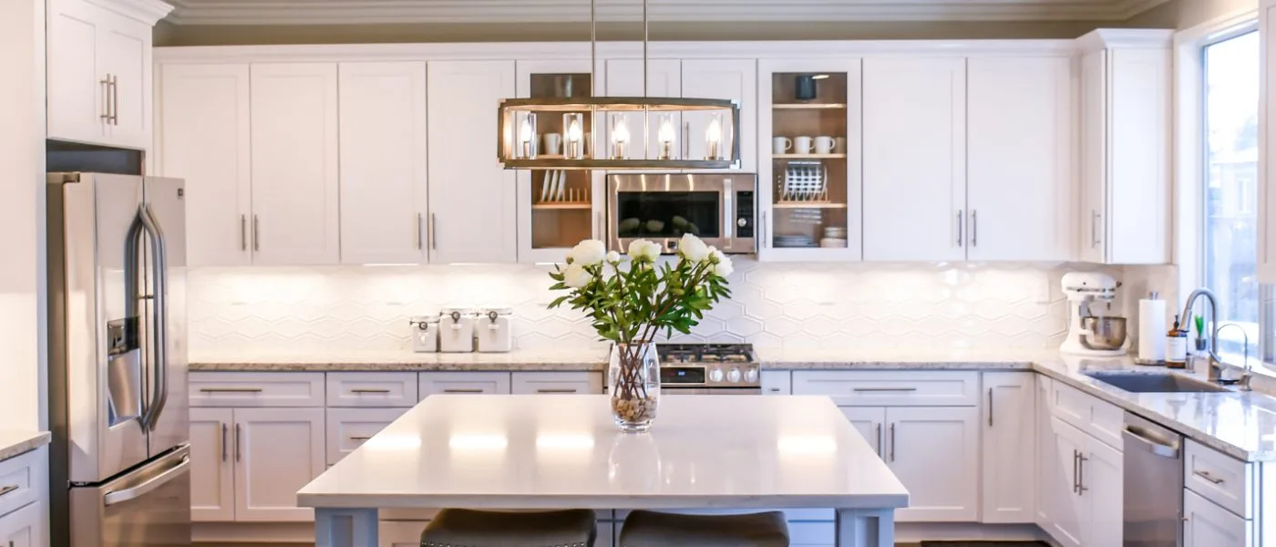 Finished kitchen renovation with new cabinetry, a granite island and pendant lighting