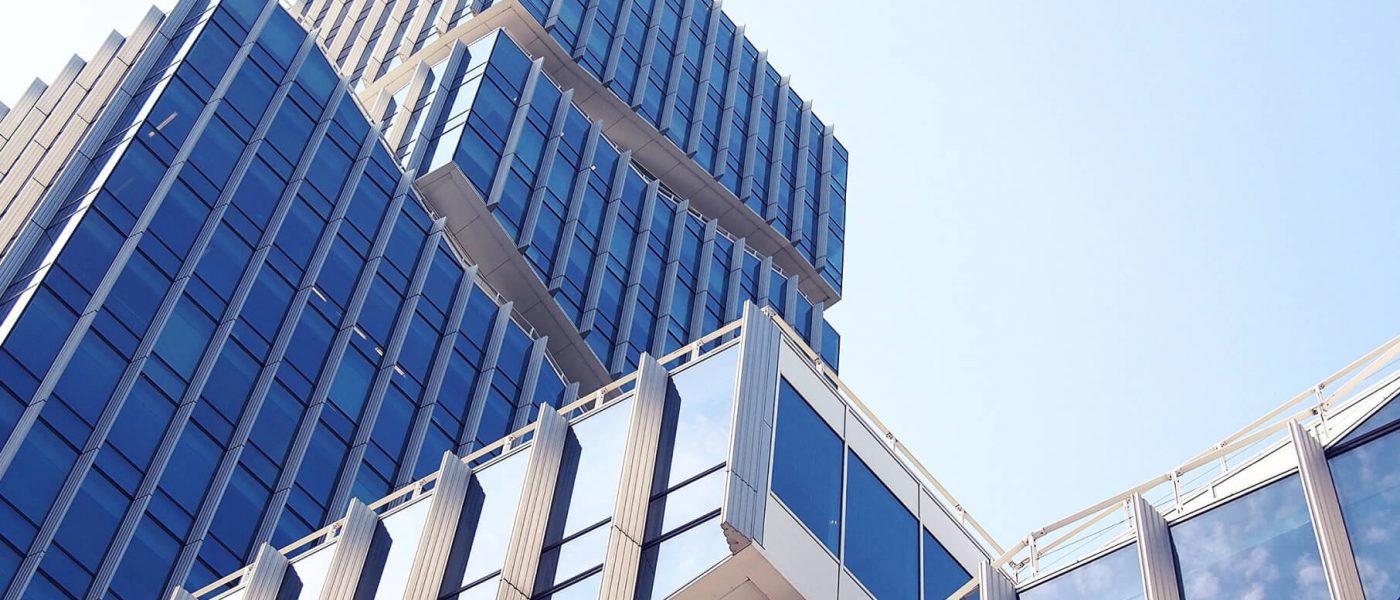 Modern glass commercial office tower viewed from street level